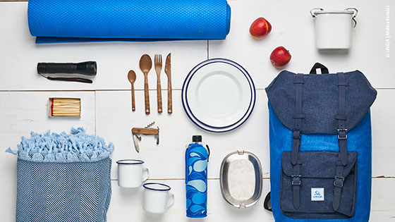 Rucksack und Reiseutensilien auf einem Tisch