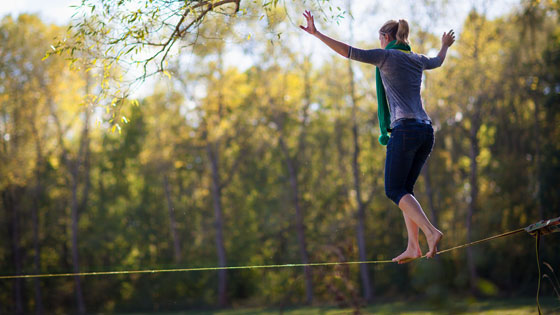 Frau auf Slackline im Park. Herbstliche Stimmung