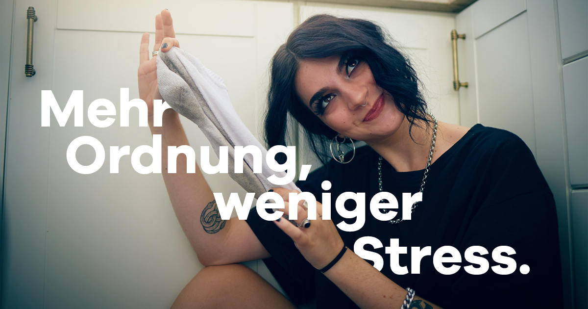 Eine junge Frau sitzt am Boden und schießt eine alte Socke weg.