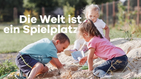 Drei Kinder spielen im Garten auf einem Sandhügel.