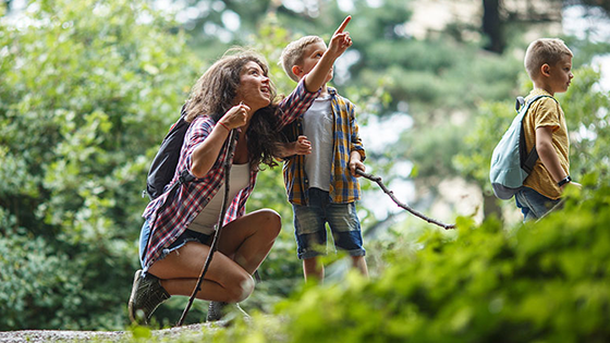 Frau mit Kindern deutet auf Wolke