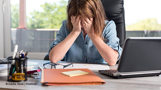 frau haende vor den augen schreibtisch