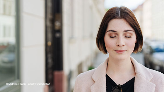 frau schliesst augen in stadt