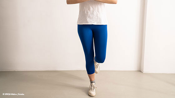 frau steht auf einem bein