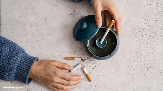 Zerbrochene Zigarette neben Aschenbecher