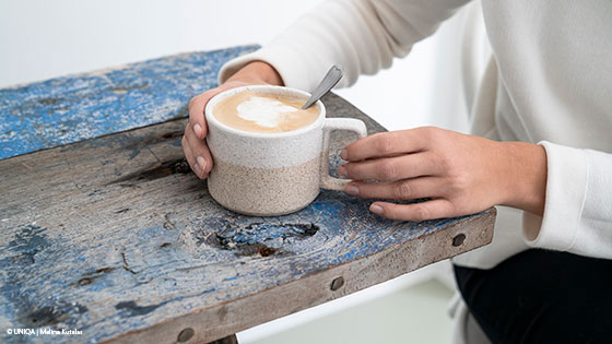 frau haelt tasse kaffee
