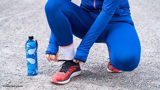 frau bindet schuhe zu