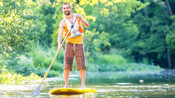 Mann steht auf einem Stand-Up Paddel