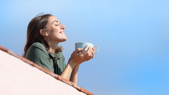 Frau genießt eine Tasse Tee in der Sonne