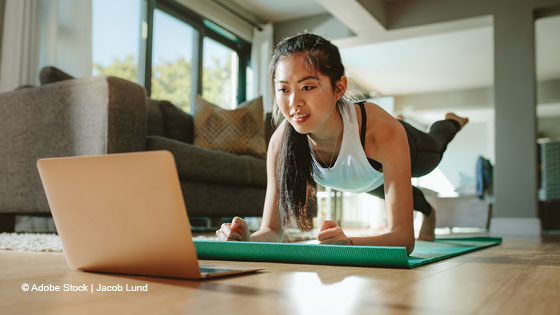 frau schaut auf laptop waehrend eigengewichtsuebung