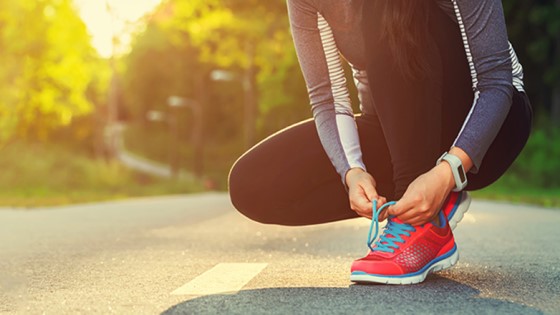 Frau bindet Laufschuhe zu