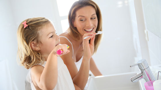 Mutter und Tochter putzen Zähne