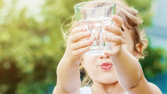 Kind haelt ein Wasserglas 