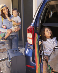 Familie beim Kofferraum-Packen