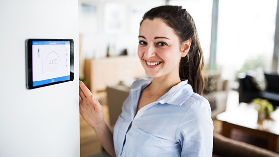 Frau steht an Temperaturregler