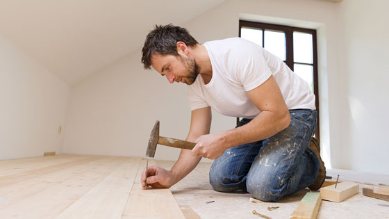 Heimwerker Mann schlägt Nägel in Holz