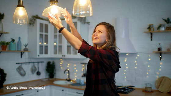 Frau schraubt Glühbirne in Fassung